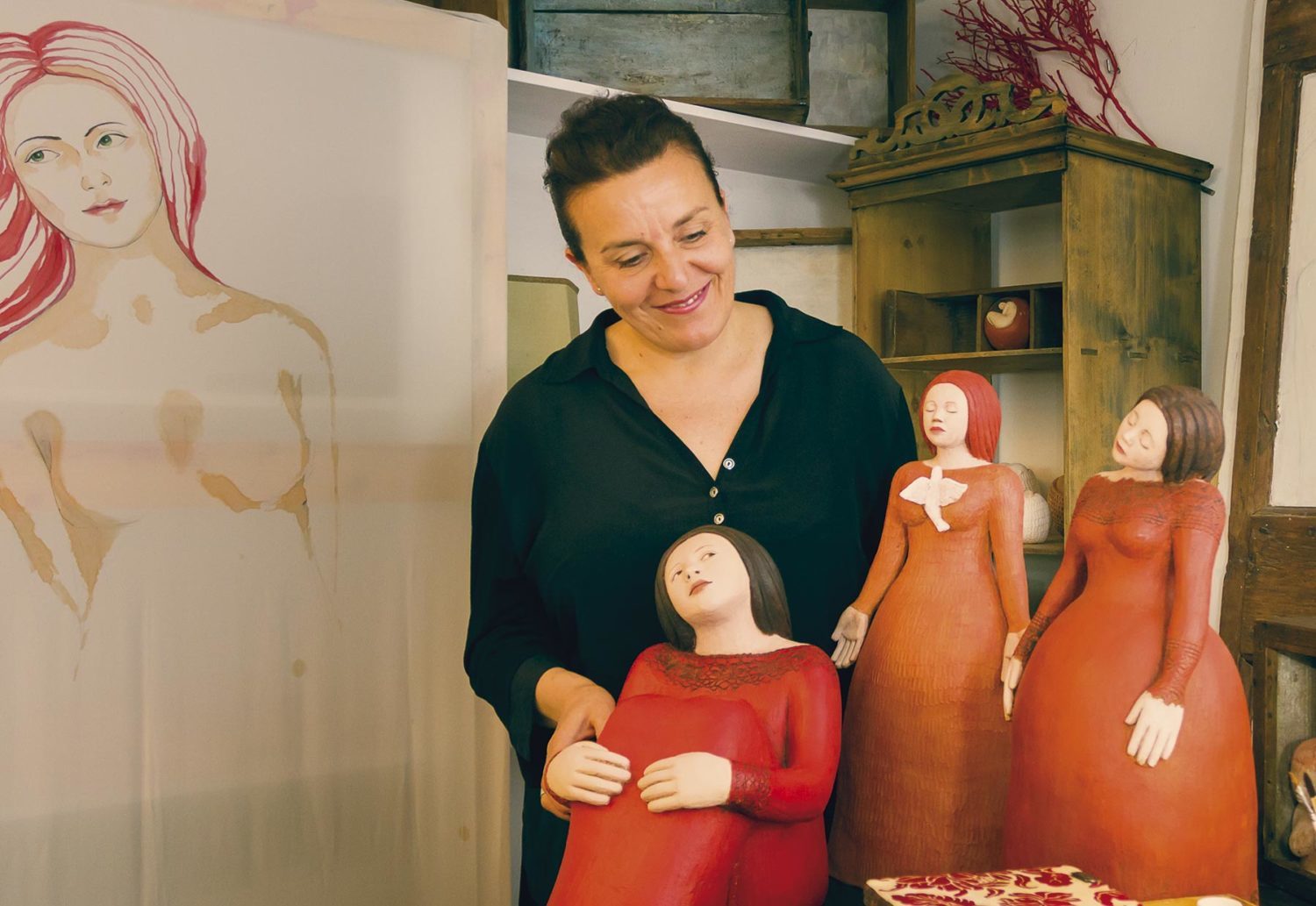 Elena Merendelli sorride accanto alle sue creazioni nella bottega/laboratorio di Anghiari